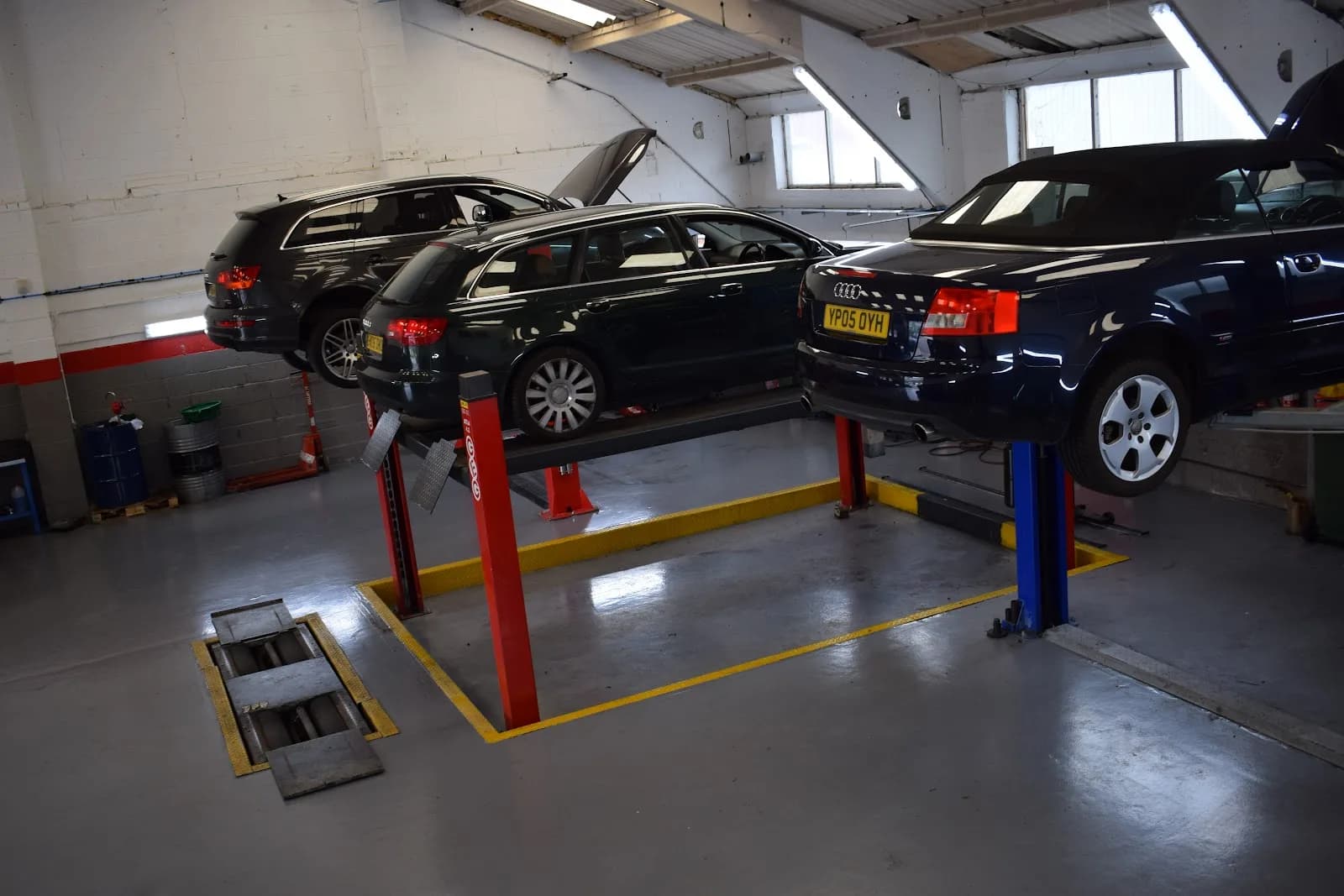 Cars on hydraulic ramps being worked on inside The Garage Sheffield